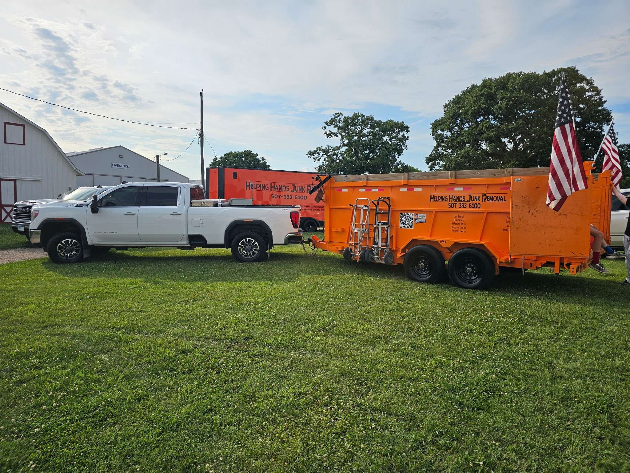 Helping Hands Junk Removal truck and dump trailer at an event